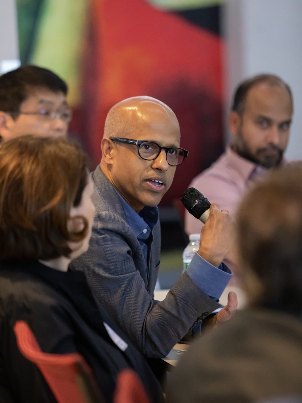 An executive speaking into a microphone during an EDC Evening Roundtable discussion.