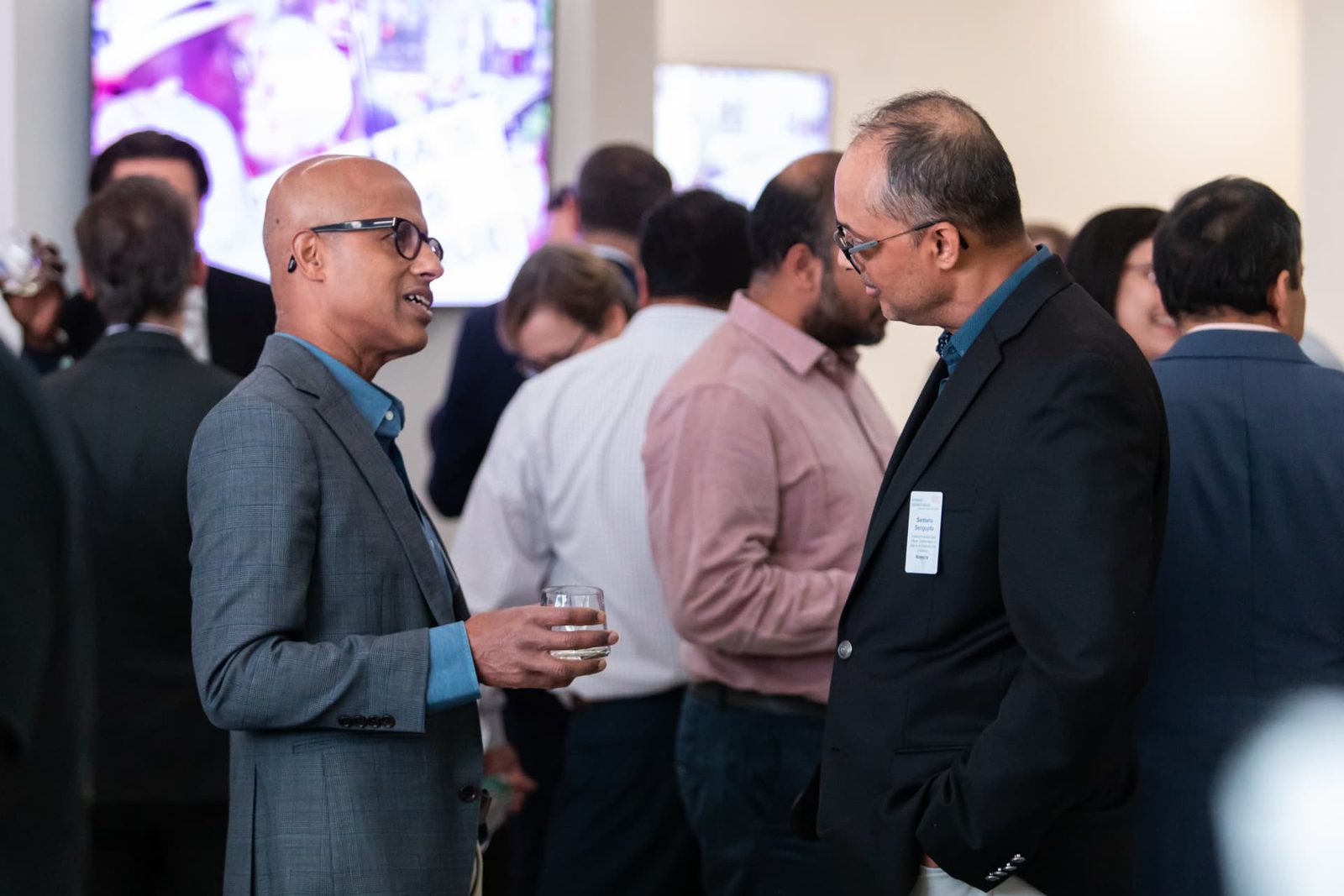Two executives continuing a private conversation at an EDC Evening Roundtable reception.