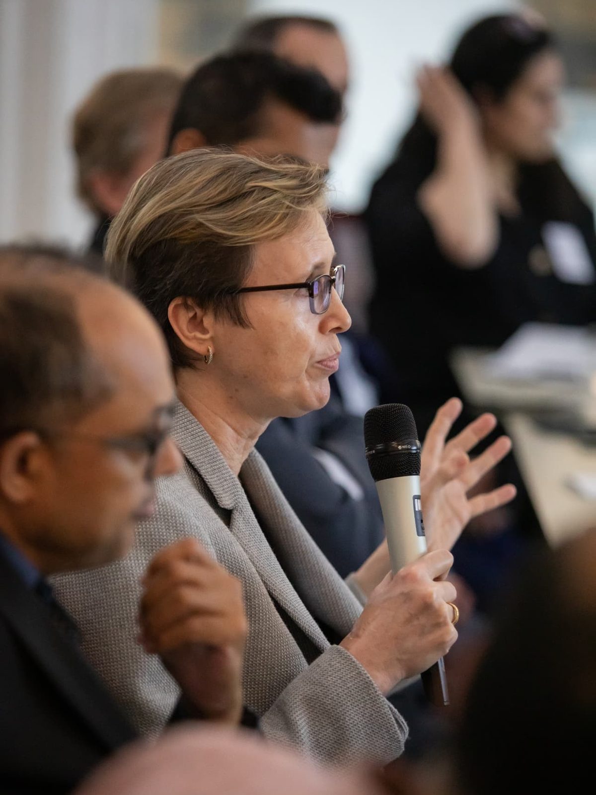 A senior executive speaking into a microphone during an EDC Evening Roundtable working session.